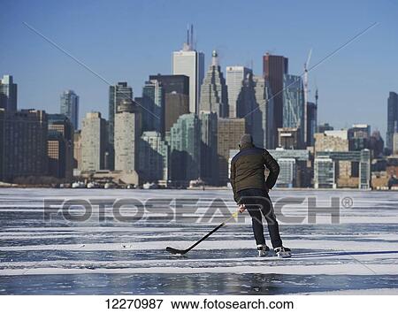 Hockey player and city skyline from Ward's Island; Toronto, Ontario, Canada View Large Photo Image Stock Photo - Hockey player and city skyline from Ward's Island; Toronto, Ontario, Canada. Fotosearch