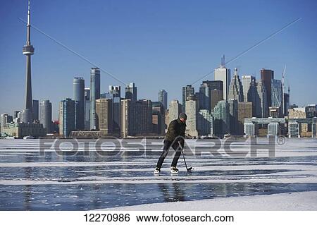 Hockey player and city skyline from Ward's Island; Toronto, Ontario, Canada View Large Photo Image Stock Photograph - Hockey player and city skyline from Ward's Island; Toronto, Ontario, Canada. Fotosearch