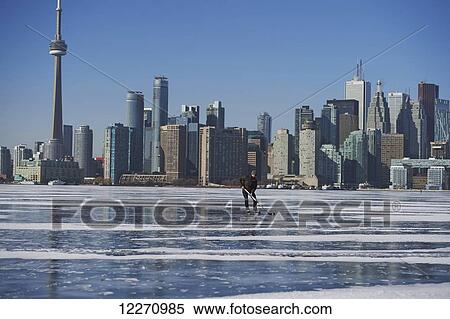 Stock Photography - Hockey player and city skyline from Ward's Island; Toronto, Ontario, Canada. Fotosearch