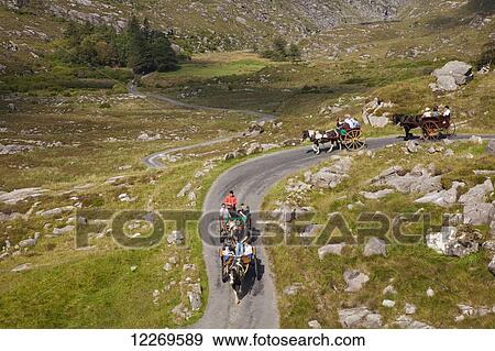 Horse and carriage rides on a road in the Gap of Dunloe; County Kerry, Ireland View Large Photo Image Stock Photo - Horse and carriage rides on a road in the Gap of Dunloe; County Kerry, Ireland. Fotosearch