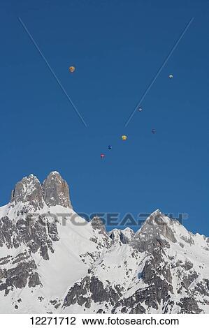 Hot air balloons floating high above snowy Bishop's Hat mountain peaks during the ski resort's annual hot air balloon festival; Filzmoos, Austria View Large Photo Image Stock Image - Hot air balloons floating high above snowy Bishop's Hat mountain peaks during the ski resort's annual hot air balloon festival; Filzmoos, Austria. Fotosearch