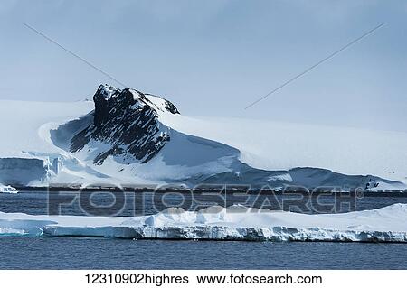 Stock Photograph - Ice formations on the water and on the coast; Antarctica. Fotosearch