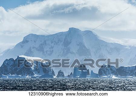 Icebergs and snow covered rock formations along the Antarctic coastline; Antarctica View Large Photo Image Stock Photograph - Icebergs and snow covered rock formations along the Antarctic coastline; Antarctica. Fotosearch