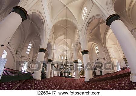 Stock Photo - Interior of a building with large white columns, archways and red carpet; Nicosia, Cyprus. Fotosearch