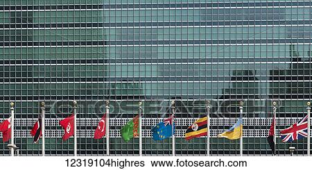 International flags in a row in front of a headquarters of the United Nations building with glass facade; New York City, New York, United States of America View Large Photo Image Stock Photograph - International flags in a row in front of a headquarters of the United Nations building with glass facade; New York City, New York, United States of America. Fotosearch