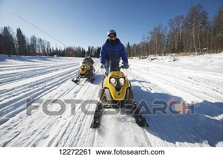 Iron Dog Adventure guide leads a snowmachine tour along the Chena River outside of Fairbanks in Interior Alaska View Large Photo Image Stock Image - Iron Dog Adventure guide leads a snowmachine tour along the Chena River outside of Fairbanks in Interior Alaska. Fotosearch