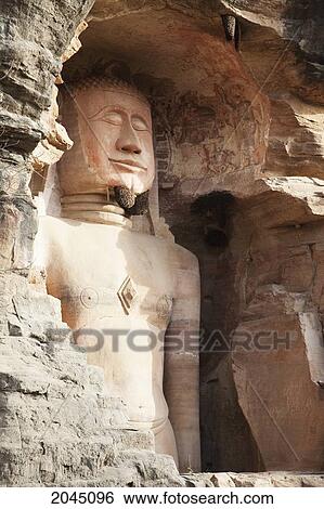 Stock Photograph - Jain Sculpture Of Adinath Carved In To The Cliff On The Southern Approach To The Fort, Gwalior, Madhya Pradesh, India. Fotosearch