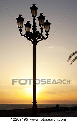 Stock Photography - Lamppost at the beach with a glowing sunset; Cadiz de la Frontera, Andalusia, Spain. Fotosearch