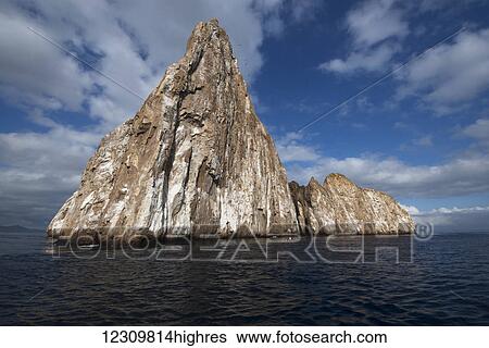 Stock Photograph - Large rock formation with peak in the ocean off the coast; Galapagos Islands, Ecuador. Fotosearch