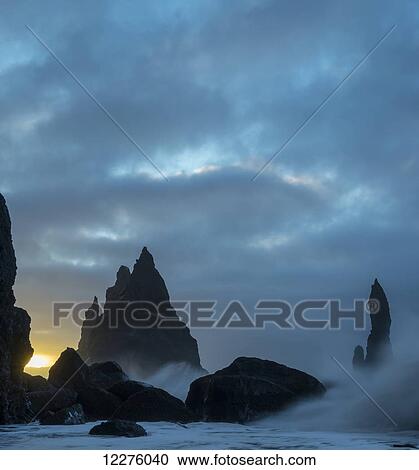 Stock Image - Large waves crash against the rocks and southern shoreline near Vik; Iceland. Fotosearch