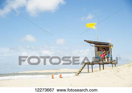 Lifeguard on duty at a lifeguarding station with a yellow flag; Valizas, Uruguay View Large Photo Image Stock Photo - Lifeguard on duty at a lifeguarding station with a yellow flag; Valizas, Uruguay. Fotosearch