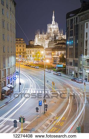 Stock Photo - Light trails on the streets with Milan Cathedral illuminated at dusk; Milan, Lombardy, Italy. Fotosearch