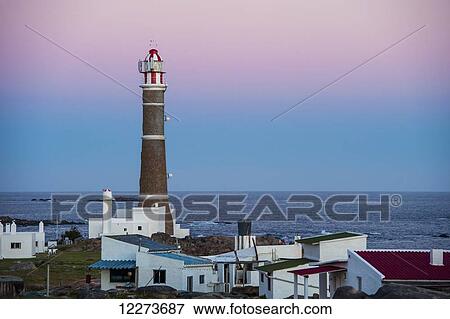 Lighthouse and houses at dusk along the coast; Cabo Polonio, Uruguay View Large Photo Image Stock Photo - Lighthouse and houses at dusk along the coast; Cabo Polonio, Uruguay. Fotosearch
