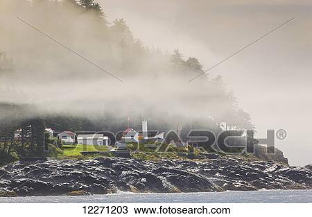 Stock Image - Lighthouse on the northwest end of Queen Charlotte Strait; Pine Island, British Columbia, Canada. Fotosearch