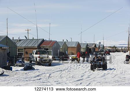 Stock Image - Locals outside on the streets of Noatak in early spring, Arctic Alaska, USA . Fotosearch