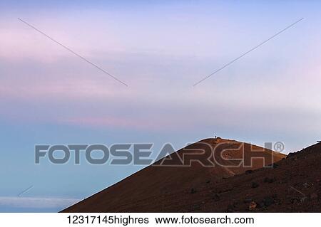 Stock Photograph - Lone figure atop 4200 meter Mauna Kea, tallest mountain in Hawaii; Island of Hawaii, Hawaii, United States of America. Fotosearch