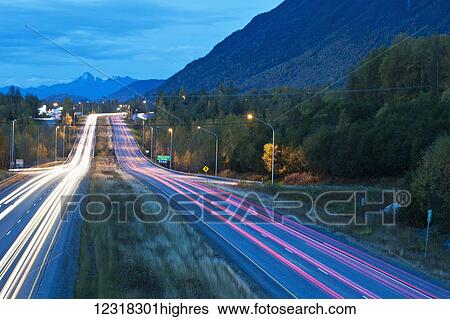 Stock Photograph - Long exposure of evening traffic on the Glenn Highway near Eagle River; Alaska, United States of America. Fotosearch