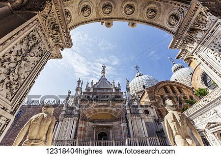 Stock Photograph - Low angle view looking out towards the chapel and St Mark's Basilica through the courtyard of Doge's Palace, Palazzo Dulce; Venice, Italy. Fotosearch