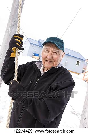 Stock Photo - Male Alaska native elder rings the church bell, Noatak, Arctic Alaska, USA. Fotosearch