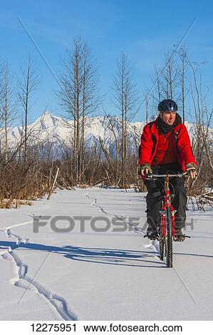 Man bicycling on frozen Rabbit Creek in the Palmer Haystack Game Refuge with Chugach Mountains in the background, Southcentral Alaska, winter View Large Photo Image Stock Image - Man bicycling on frozen Rabbit Creek in the Palmer Haystack Game Refuge with Chugach Mountains in the background, Southcentral Alaska, winter. Fotosearch
