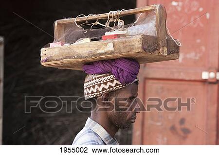 Stock Image - Man carrying a tool box at the Metal Recycling Market in Bamako, Mali. Fotosearch