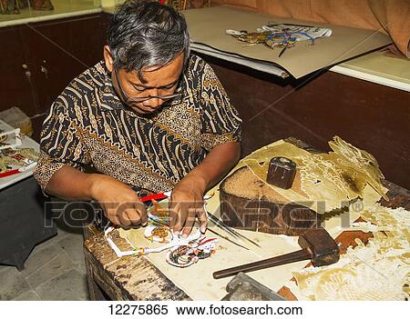 Man chiselling leather with very fine tools in the construction of a Wayang Kulit shadow puppet, Yogyakarta, Java Island, Indonesia View Large Photo Image Stock Photography - Man chiselling leather with very fine tools in the construction of a Wayang Kulit shadow puppet, Yogyakarta, Java Island, Indonesia. Fotosearch
