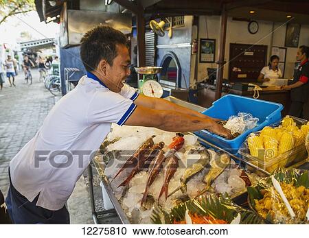 Stock Image - Man icing fresh seafood, Gili Trawangan, West Nusa Tenggara, Indonesia. Fotosearch