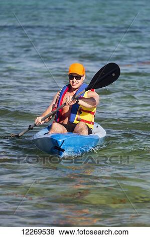 Man in kayak paddling in water; Akumal, Quintana Roo, Mexico View Large Photo Image Stock Photo - Man in kayak paddling in water; Akumal, Quintana Roo, Mexico. Fotosearch