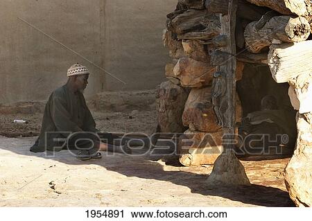 Man sitting by the Toguna (House of Words) in Sangha, Mali View Large Photo Image Stock Image - Man sitting by the Toguna (House of Words) in Sangha, Mali. Fotosearch