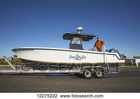 Man standing in his boat on a trailer; Montauk, New York, United States of America View Large Photo Image Stock Image - Man standing in his boat on a trailer; Montauk, New York, United States of America. Fotosearch