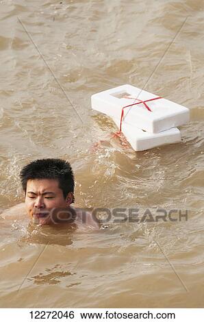 Man swimming in Yangtze river with a unique handmade float; Wuhan, Hubei province, China View Large Photo Image Stock Photograph - Man swimming in Yangtze river with a unique handmade float; Wuhan, Hubei province, China. Fotosearch