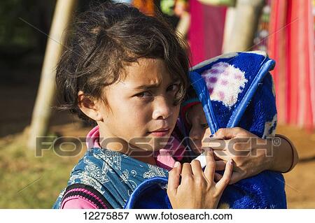 Stock Photo - Manggarai girl holding a baby, Melo village, Flores, East Nusa Tenggara, Indonesia. Fotosearch