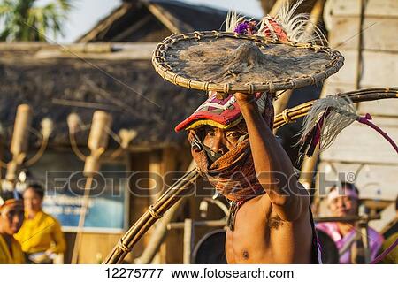 Stock Photo - Manggarai man wearing a traditional headdress wrapped with cloth wielding a shield and bamboo whip in a caci, a ritual whip fight, Melo village, Flores, East Nusa Tenggara, Indonesia. Fotosearch
