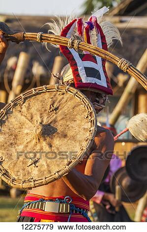 Stock Photo - Manggarai man wearing a traditional headdress wrapped with cloth wielding a shield and bamboo whip in a caci, a ritual whip fight, Melo village, Flores, East Nusa Tenggara, Indonesia. Fotosearch