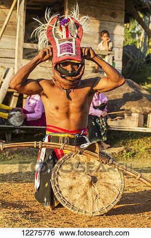 Manggarai man wearing a traditional headdress wrapped with cloth wielding a shield and bamboo whip in a caci, a ritual whip fight, Melo village, Flores, East Nusa Tenggara, Indonesia View Large Photo Image Stock Photograph - Manggarai man wearing a traditional headdress wrapped with cloth wielding a shield and bamboo whip in a caci, a ritual whip fight, Melo village, Flores, East Nusa Tenggara, Indonesia. Fotosearch