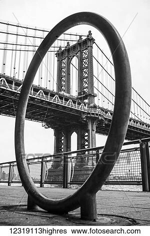 Stock Photograph - Manhattan bridge viewed through a circular structure on the promenade; New York City, New York, United States of America. Fotosearch