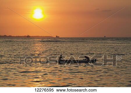 Men in a boat at sunset; Dili, East Timor View Large Photo Image Stock Photography - Men in a boat at sunset; Dili, East Timor. Fotosearch
