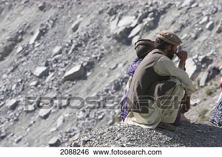 Stock Photograph - Men Sitting By The Side Of The Road, Dasu, North-West Frontier Province, Pakistan. Fotosearch