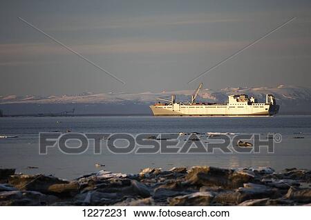 Stock Image - Military cargo ship traveling up Knik Arm to the port of Anchorage at high tide, Anchorage, Southcentral Alaska, USA.. Fotosearch