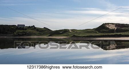 Stock Photograph - Mirror reflection of the landscape along the Atlantic coast; Mabou, Nova Scotia, Canada. Fotosearch
