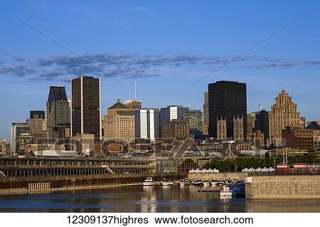 Stock Photograph - Montreal skyline and boats in a harbour; Montreal, Quebec, Canada. Fotosearch