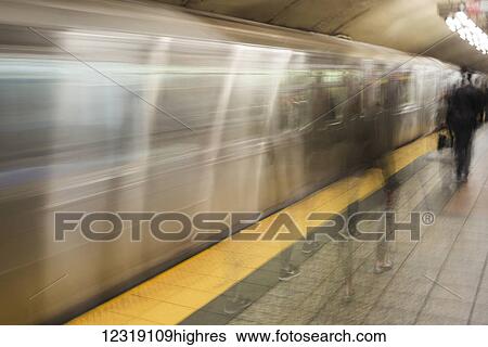 Motion blur of passengers walking on the platform beside the moving subway; New York City, New York, United States of America View Large Photo Image Stock Photograph - Motion blur of passengers walking on the platform beside the moving subway; New York City, New York, United States of America. Fotosearch