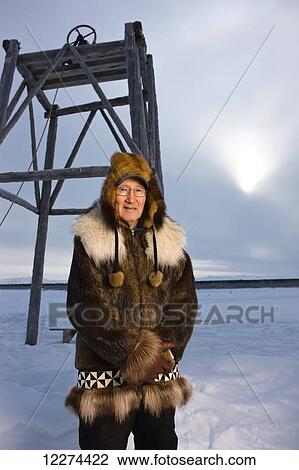Native Alaskan elder in a beaver fur parka stands in front of a church bell during winter, Noatak, Arctic Alaska, USA View Large Photo Image Stock Image - Native Alaskan elder in a beaver fur parka stands in front of a church bell during winter, Noatak, Arctic Alaska, USA. Fotosearch