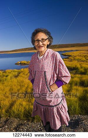 Native Alaskan elder woman wearing an Atigik standing on the Tundra with a small lake in the background, Fall, Kotzbue, Arctic Alaska, USA. View Large Photo Image Stock Image - Native Alaskan elder woman wearing an Atigik standing on the Tundra with a small lake in the background, Fall, Kotzbue, Arctic Alaska, USA.. Fotosearch