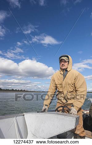 Native Alaskan man driving a skiff on the Noatak River, Noatak, Arctic Alaska, USA, Fall View Large Photo Image Stock Photo - Native Alaskan man driving a skiff on the Noatak River, Noatak, Arctic Alaska, USA, Fall . Fotosearch