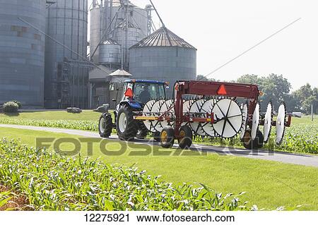 Stock Image - New Holland T5040 with H5980 wheel rake; New Holland, Pennsylvania, United States of America. Fotosearch