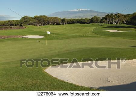 Picture - North Course at Francis Ii Brown Golf Course at the Mauna Lani Resort, 9th hole par 4 with snow covered Mauna Kea in background; Island of Hawaii, Hawaii, United States of America. Fotosearch