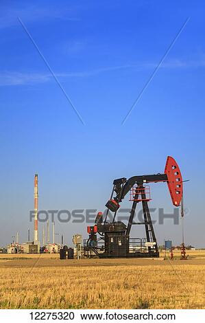 Stock Image - Oil well pumpjack of Bakken Oilfield with natural gas plant near Glen Ewen; Saskatchewan, Canada. Fotosearch