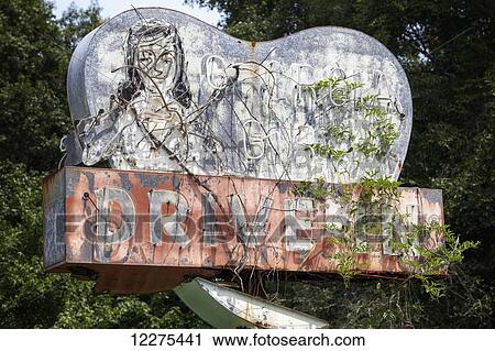 Old, abandoned drive-in restaurant sign with faded color and chipped, missing paint overgrown with vines; Georgia, United States of America View Large Photo Image Stock Image - Old, abandoned drive-in restaurant sign with faded color and chipped, missing paint overgrown with vines; Georgia, United States of America. Fotosearch