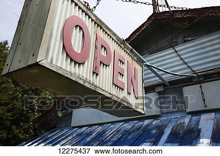 Stock Photo - Old sign that says open hanging from chains from the front of an abandoned BBQ restaurant; United States of America. Fotosearch